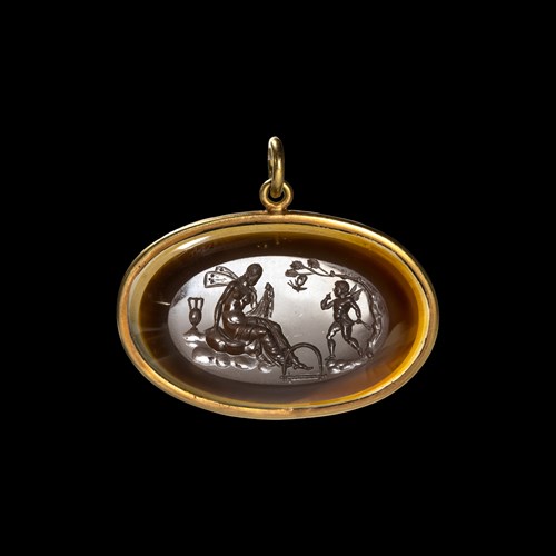 A gold pendant set with a large Neoclassical agate intaglio. Cupid saving Psyche.